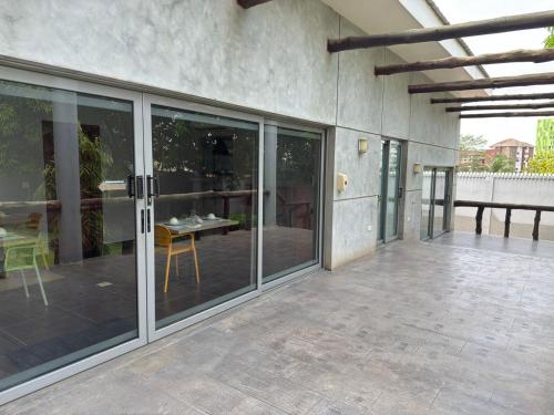 an outdoor patio with glass doors and a table at CasaNova Airport Suites in Accra