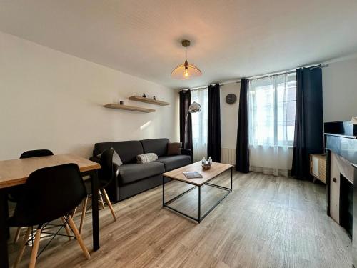 un salon avec un canapé et une table dans l'établissement Le Lodge - Lit King Size - 2 à 4 personnes - Proche Gare, à Nancy
