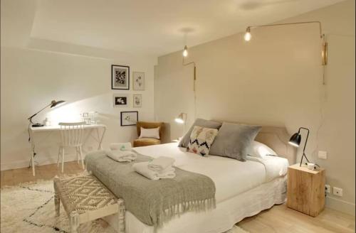 - une chambre avec un grand lit blanc et une table dans l'établissement Superbe appartement aux Halles I, à Paris