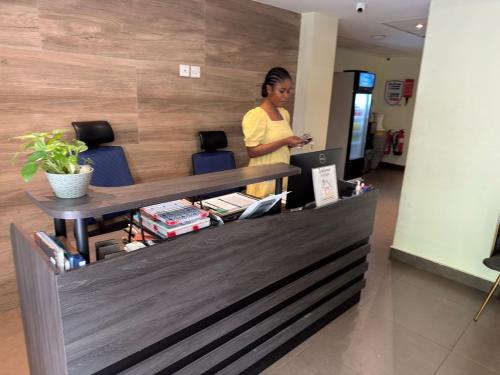 a woman standing at a counter in an office at CasaNova Airport Suites in Accra