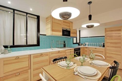 une cuisine avec une table en bois et des plaques de cuisson. dans l'établissement Superbe appartement aux Halles I, à Paris