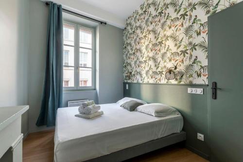 une chambre avec un lit avec une grande fenêtre dans l'établissement Le Mignon Croix-Roussien - 2 voyageurs, à Lyon
