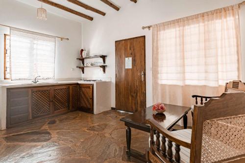 a living room with a table and a kitchen at Exploreans Malaika Villas and Beach Club in Malindi