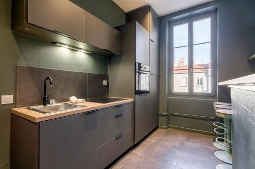 une petite cuisine avec un évier et une fenêtre dans l'établissement Le Mignon Croix-Roussien - 2 voyageurs, à Lyon