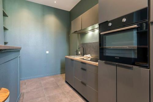 une cuisine avec un évier et un micro-ondes dans l'établissement Le Mignon Croix-Roussien - 2 voyageurs, à Lyon