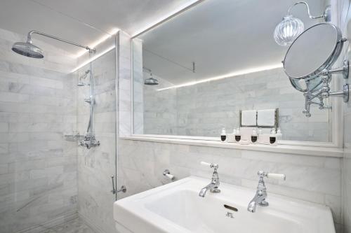 a white bathroom with a sink and a mirror at The Roseate Villa Bath in Bath