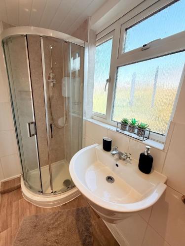 a white bathroom with a shower and a sink at Wembley Rooms in London