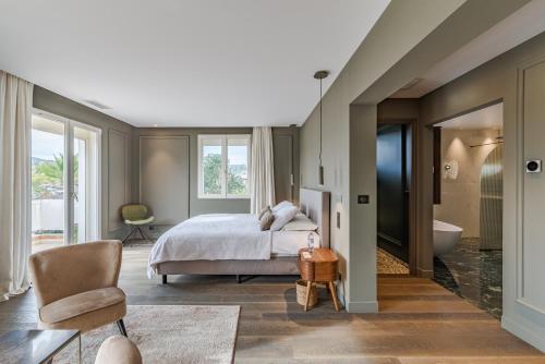 une chambre avec un lit et une salle de bain avec baignoire dans l'établissement Karine By Terrys Homes, à Villeneuve-Loubet
