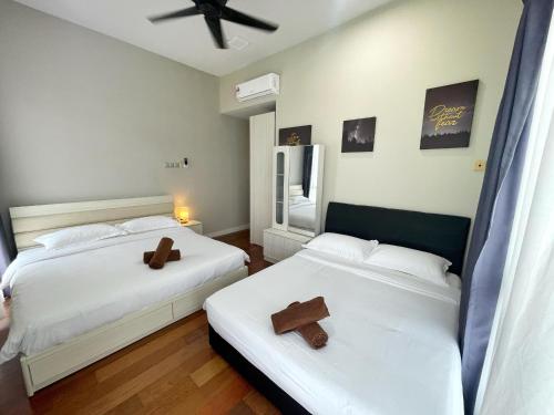 two beds in a bedroom with two crosses on them at Ezyhouz - IMAGO The Loft in Kota Kinabalu