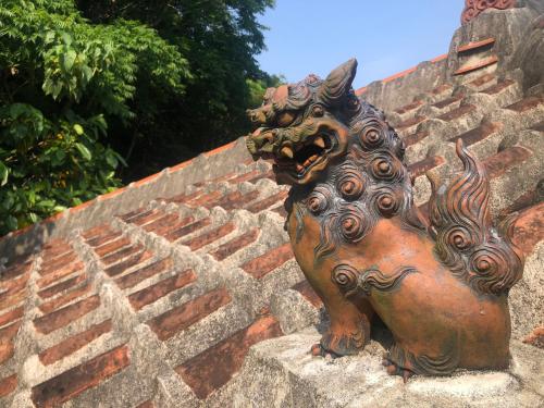 a statue of a dragon sitting on a brick stairs at Habuman Okinawa in Kunigami