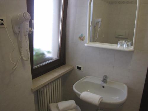 a bathroom with a sink and a window and a phone at Residence Villa Margherita in Brenzone sul Garda