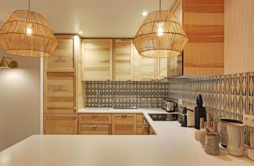 - une cuisine avec deux lustres et un comptoir blanc dans l'établissement Sublime apartment - Halles II, à Paris