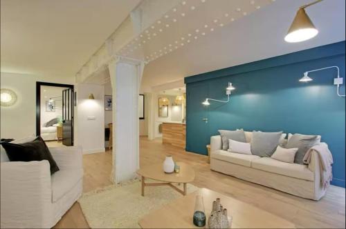 - un salon avec deux canapés blancs et un mur bleu dans l'établissement Sublime apartment - Halles II, à Paris