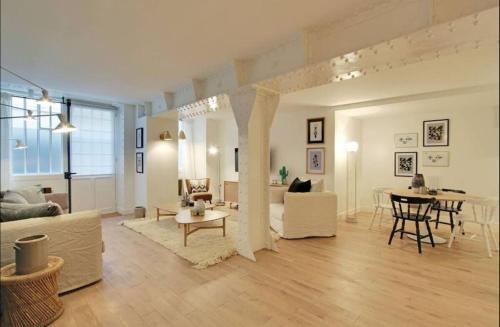 Il comprend un salon doté d'un mobilier blanc et une salle à manger. dans l'établissement Sublime apartment - Halles II, à Paris