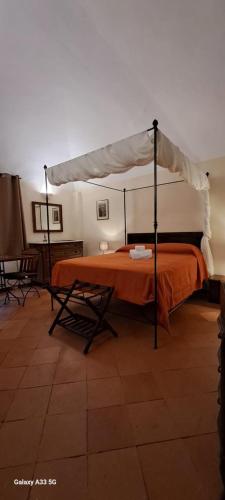a bed with an orange comforter in a room at Oryza Guest House in Desana