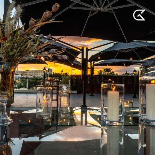 a table with candles and umbrellas on a patio at Golden Tulip Président Hammamet in Hammamet