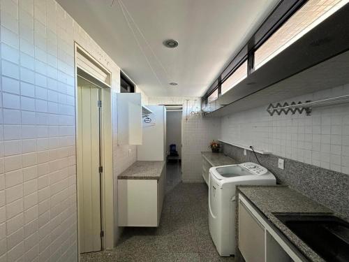 a bathroom with a sink and a washing machine at Apartamento em João Pessoa - Frente Pro Mar in João Pessoa