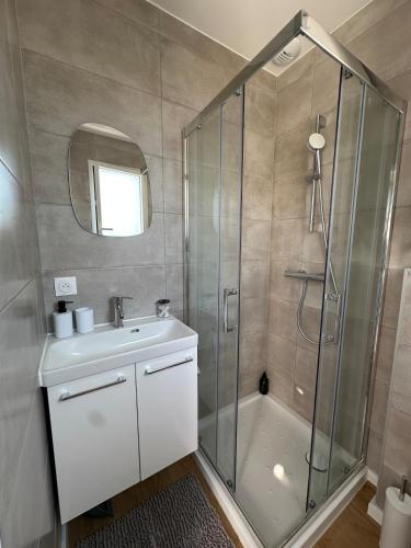 a bathroom with a shower and a sink and a mirror at Entre Nantes et aéroport - Arrivée autonome 24h sur 24h in La Montagne
