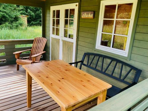 a porch with a wooden table and two chairs at Aroha Cabin in Sänna