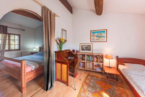 une chambre avec un lit, une table et un bureau dans l'établissement Le Pijouret - Appt avec piscine privée, à Brignoles