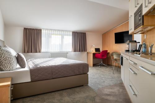 a hotel room with a bed and a kitchen at Hotel Osvit in Mladá Boleslav