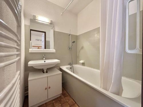 une salle de bain blanche avec un lavabo et une baignoire dans l'établissement Studio cosy à Notre-Dame-de-Bellecombe, proche des pistes et commerces - 4 pers, balcon, parking - FR-1-595-25, à Notre-Dame-de-Bellecombe