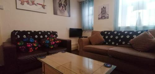 a living room with two couches and a coffee table at Birchwood Apartment in Llandudno