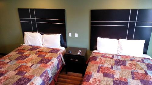 a hotel room with two beds and a headboard at Gene's Motel in Cinnaminson
