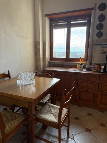 a kitchen with a wooden table with chairs and a window at PUNTO FM Venezia in Venice