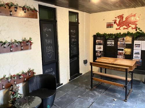 a room with a table and a door with a horse on the wall at Yr Hen Ysgol- The Old Primary School in Llanddeusant