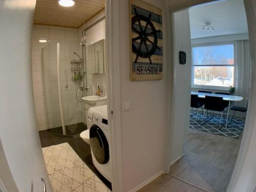 a bathroom with a sink and a washing machine in it at Kaupunkikoti 3-room apartment A3 in Kemi