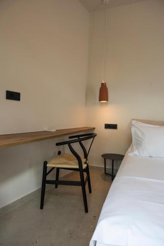 a bedroom with a desk and a chair next to a bed at Gioma Garden Villas in Istron