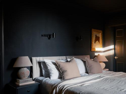 a bedroom with a large bed with white pillows at Cambridge House in Windermere