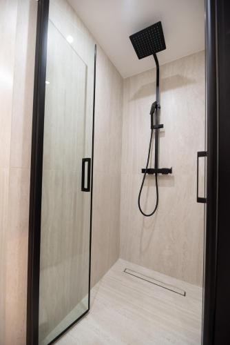 une douche dans une salle de bain avec une porte vitrée dans l'établissement Cosy Studio with Prime Location, Le Marais, à Paris