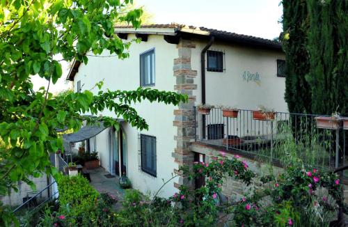 a white house with flowers in front of it at Agriturismo il Pino - Bioagricoltura in Monticello