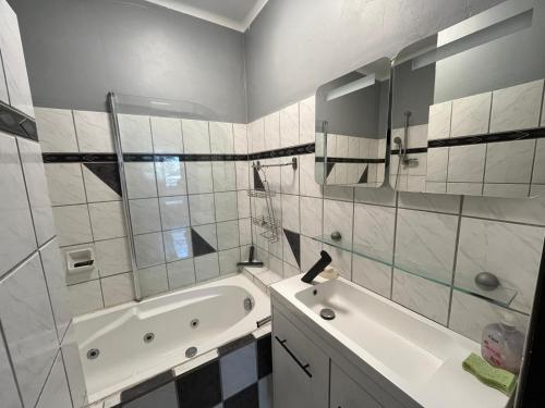 une salle de bain blanche avec une baignoire et un lavabo dans l'établissement Maison La Falaise avec piscine, à Narbonne-Plage