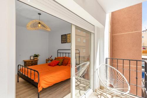 a bedroom with a bed and two chairs on a balcony at Casa Woopi Torrevieja in Torrevieja