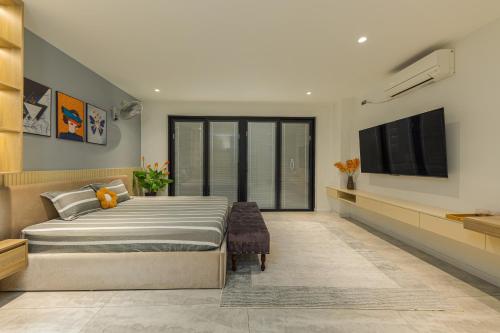 a bedroom with a large bed and a flat screen tv at Thảo Nguyên Homestay in Hanoi