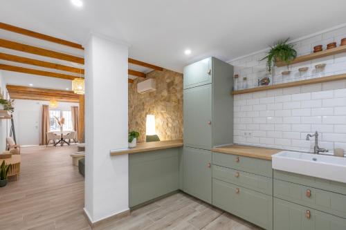 a kitchen with green cabinets and a sink at Casa Woopi Torrevieja in Torrevieja