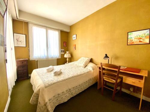 une petite chambre avec un lit et un bureau dans l'établissement Happy Days - 5 chambres- jardín Parenthèse rétro en famille, à Friaucourt