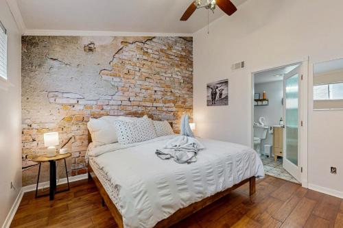 a bedroom with a brick wall and a bed at ‘Lakeside Getaway’ w/ Patio on Lady Bird Lake in Austin