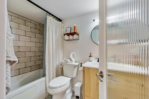 a bathroom with a toilet and a tub and a sink at ‘Lakeside Getaway’ w/ Patio on Lady Bird Lake in Austin