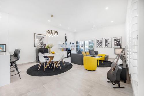 a living room with a table and yellow chairs at Fairway Sleek Chic in Palm Springs