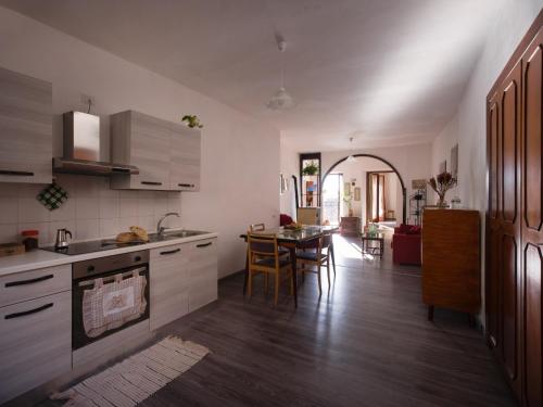 a kitchen with white cabinets and a table in it at La casa di nonna Clara in Montecchio