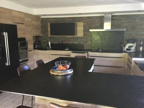 a kitchen with a table with a bowl of fruit on it at LA MAISON D'ULYSSE spa et détente in Anould