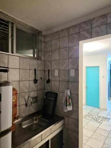 Una cocina con fregadero y pared de azulejos. en Casa Ayê Mia, en Salvador