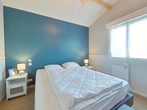 une chambre avec un grand lit avec un mur bleu dans l'établissement Maison 5 pièces avec wifi, près plage et centre, Brem sur Mer - FR-1-224A-73, à Brem-sur-Mer