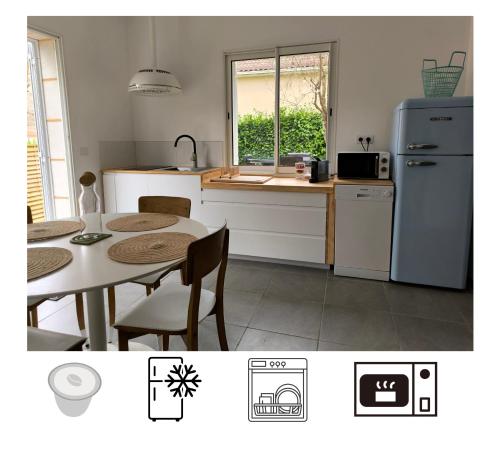 une cuisine avec une table et un réfrigérateur dans l'établissement L'entre-deux, à Périgueux