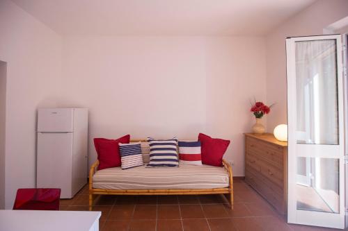 a room with a bench with red and blue pillows at Capo Bianco Terrace - Helloelba in Portoferraio