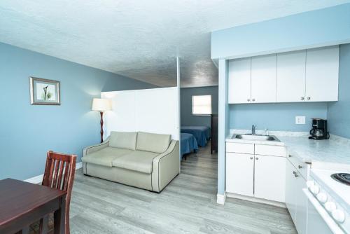 a kitchen with a couch and a chair in a room at Sunrise Resort Motel South in Clearwater Beach